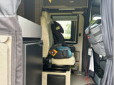 Inside this RV rental: A child booster seat, compact refrigerator, and storage in a camper van.