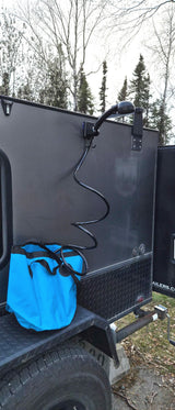 Outdoor shower on an rv rental trailer, featuring a coiled hose & blue bucket. Ideal for camping & road trips.