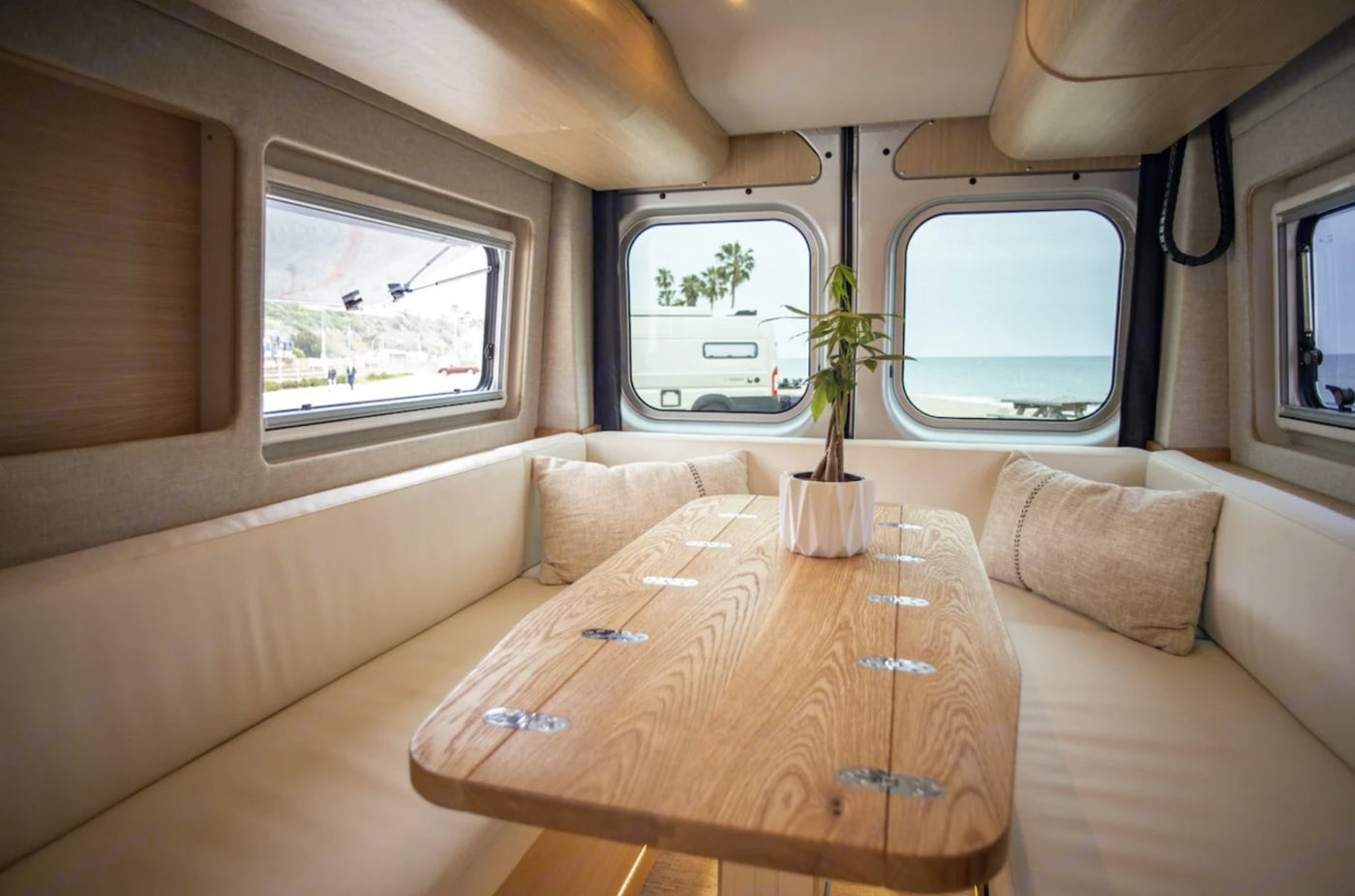  and a bright dinette.|Modern RV rental interior with elevated bed — photo 7