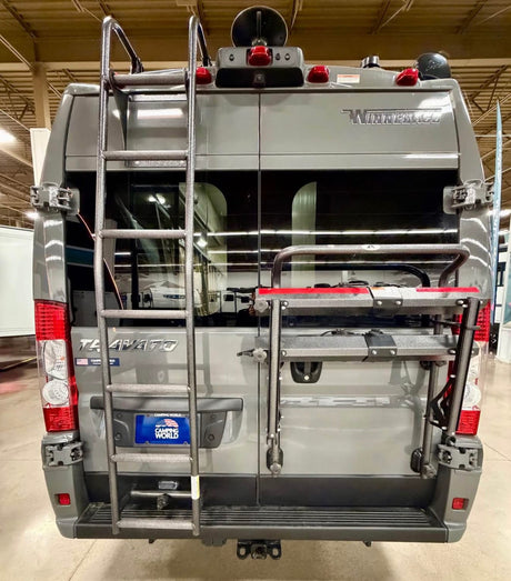 Rear view of a grey Winnebago Travato camper van, perfect for an RV rental adventure. Features a ladder and bike rack.