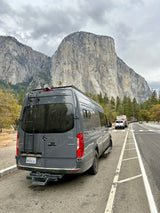 Grey Sprinter rv rental van parked roadside, facing towering El Capitan in Yosemite. Great mountain views.