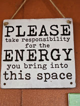 White sign with text 'PLEASE take responsibility for the ENERGY you bring into this space', ideal for an RV rental.