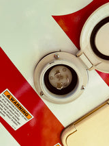 An RV rental shore power inlet with a warning for 110-125V, 30 amp supply. Essential for safe electrical hookup.