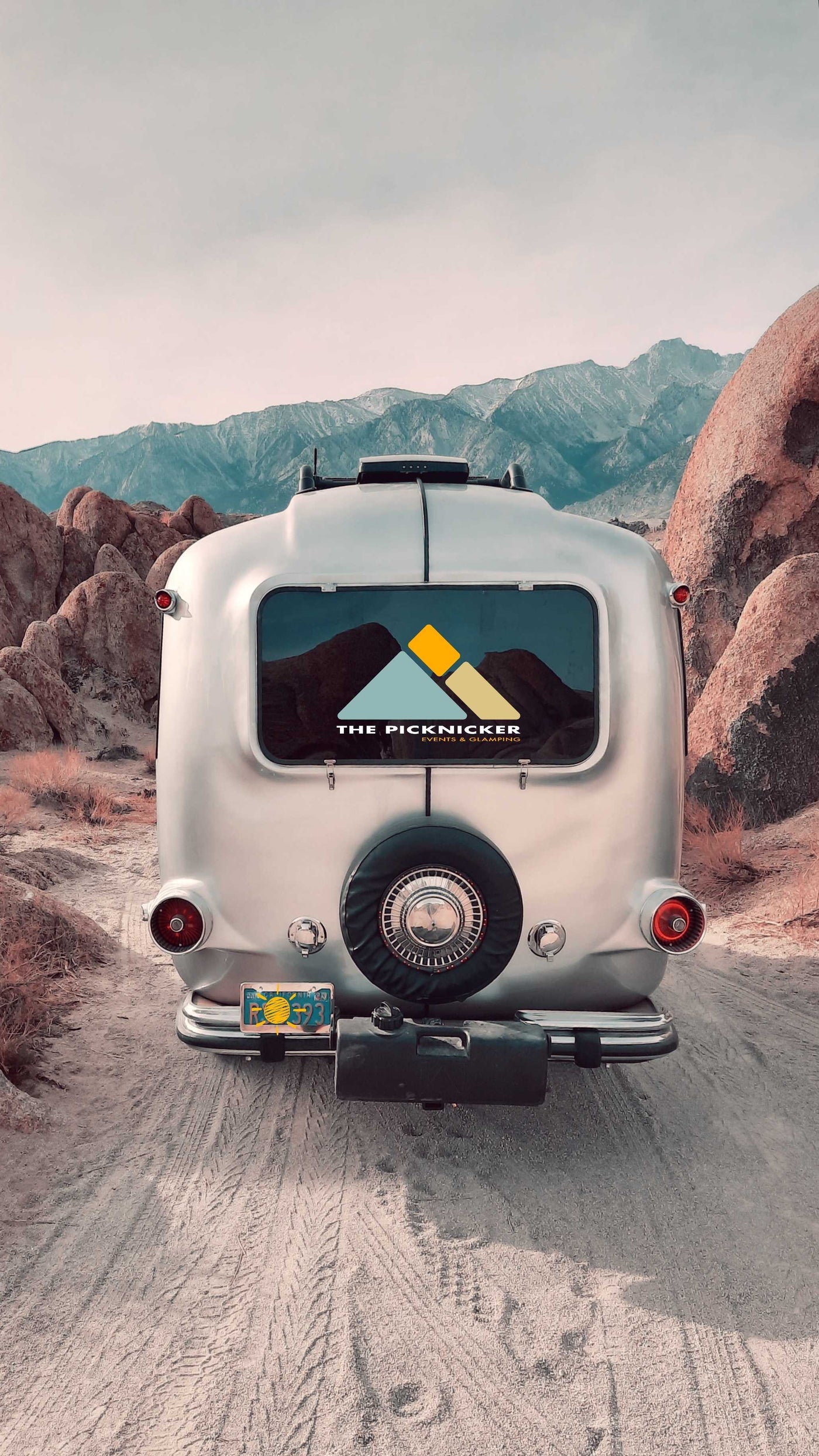 A silver RV rental on a dirt road, framed by mountains & desert rocks. Ready for your next glamping trip! — photo 7