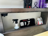 RV rental organization: compact heater, Nalgene bottle, and a cubby holding cleaning spray, tech gear, and Huggies wipes.