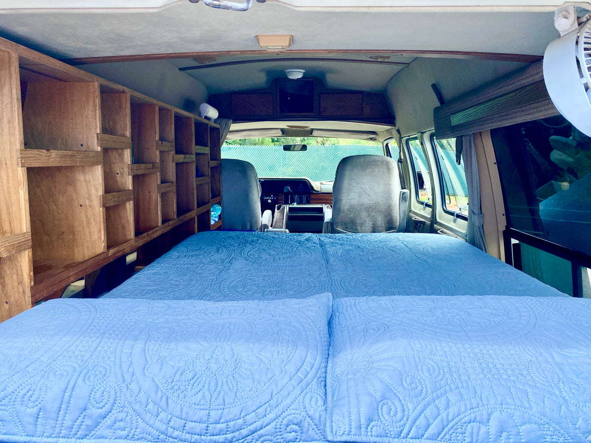 Explore this RV rental interior: a comfy bed, custom wooden shelving, and the front cabin view. — photo 10