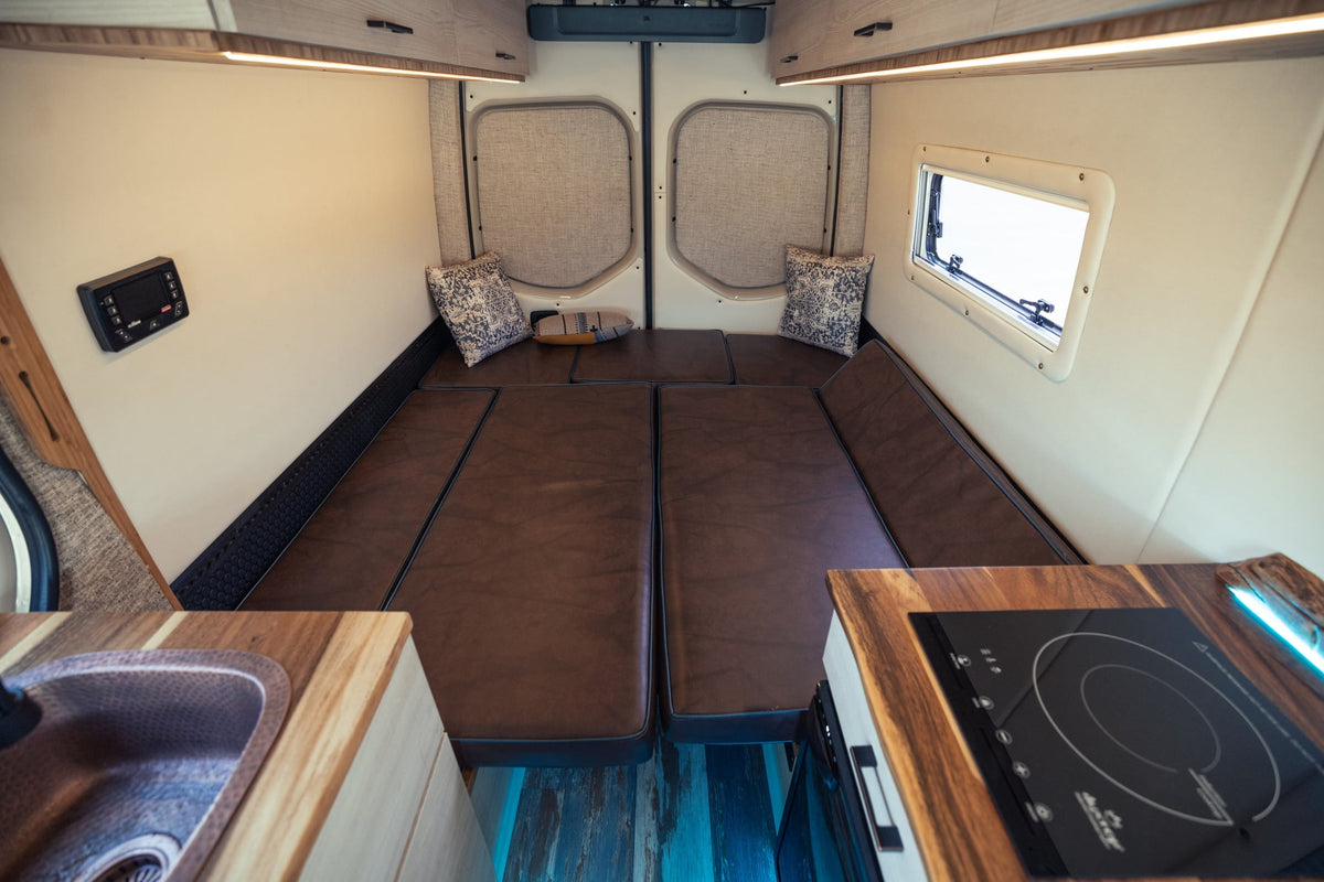  custom-built cream 4x4 Sprinter camper van RV rental with off-road tires and roof rack.|Inside a customized rv rental camper van: Swiveled passenger seat — photo 14