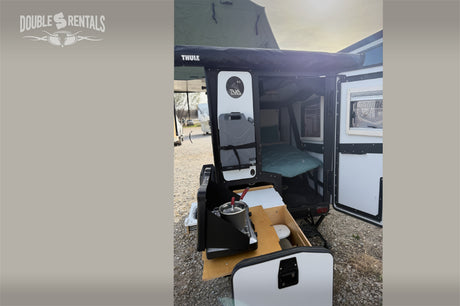 RV rental: TAXA Outdoors camping trailer with open side showing bed, outdoor kitchen & Thule awning.