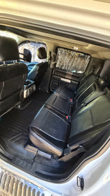 View of clean black leather rear seats and floor mats in a spacious vehicle interior. Great for your rv rental trip.