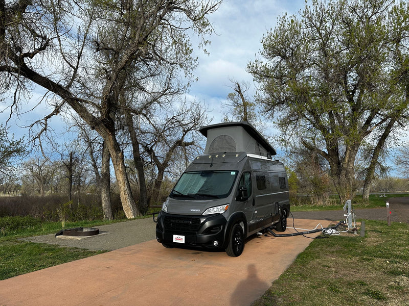  hooked up to utilities by a fire pit.|A gray Winnebago Solis camper van RV rental — photo 7