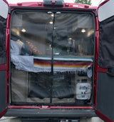 Discover comfort with this RV rental! Rear view of a camper van interior, showcasing a cozy bed and protective mesh screen.