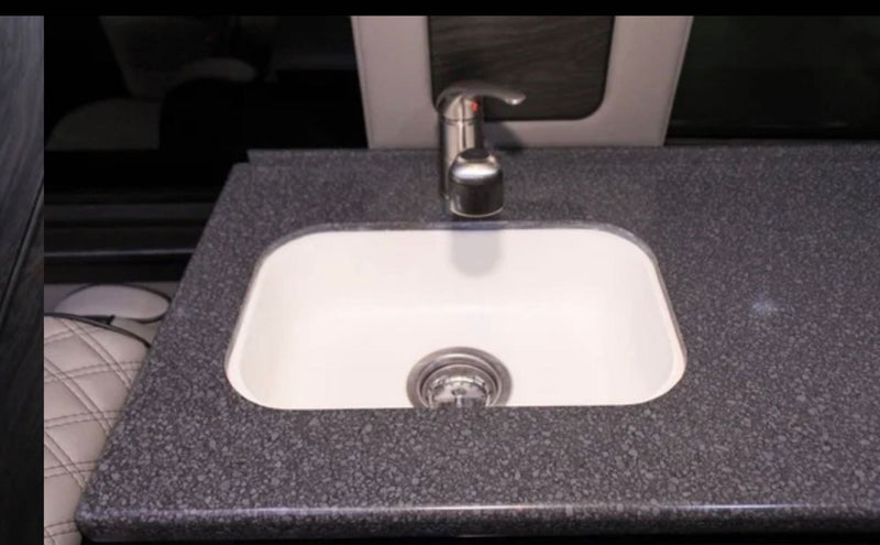 RV rental interior: A white sink with a sleek faucet set into a dark, speckled countertop. Functional and compact kitchen space. — photo 15