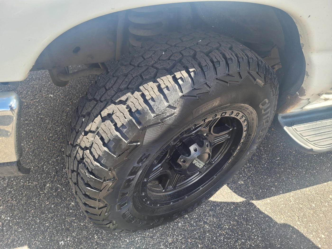 Front wheel of an RV rental vehicle, with a rugged Nokian Outpost AT tire on a black Ultra Motorsports rim. Parked on asphalt. — photo 3