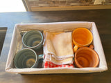 Colorful mugs & kitchen towels neatly stored in a basket, perfect for your next RV rental adventure. Compact kitchen essentials.