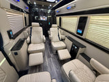 Plush RV rental interior: cream leather captain's chairs, footrests, smart controls, and entertainment for luxury travel.