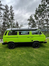 A vibrant lime green VW Vanagon camper van is parked on green grass. Ideal for an RV rental & outdoor adventures!