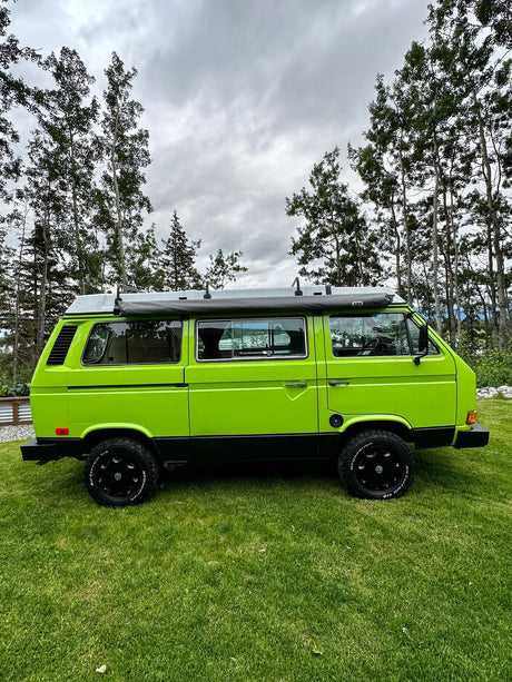 A vibrant lime green VW Vanagon camper van is parked on green grass. Ideal for an RV rental & outdoor adventures!