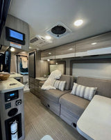 Explore this modern rv rental interior with cozy seating, kitchenette, ceiling fan, and easy-to-use controls.