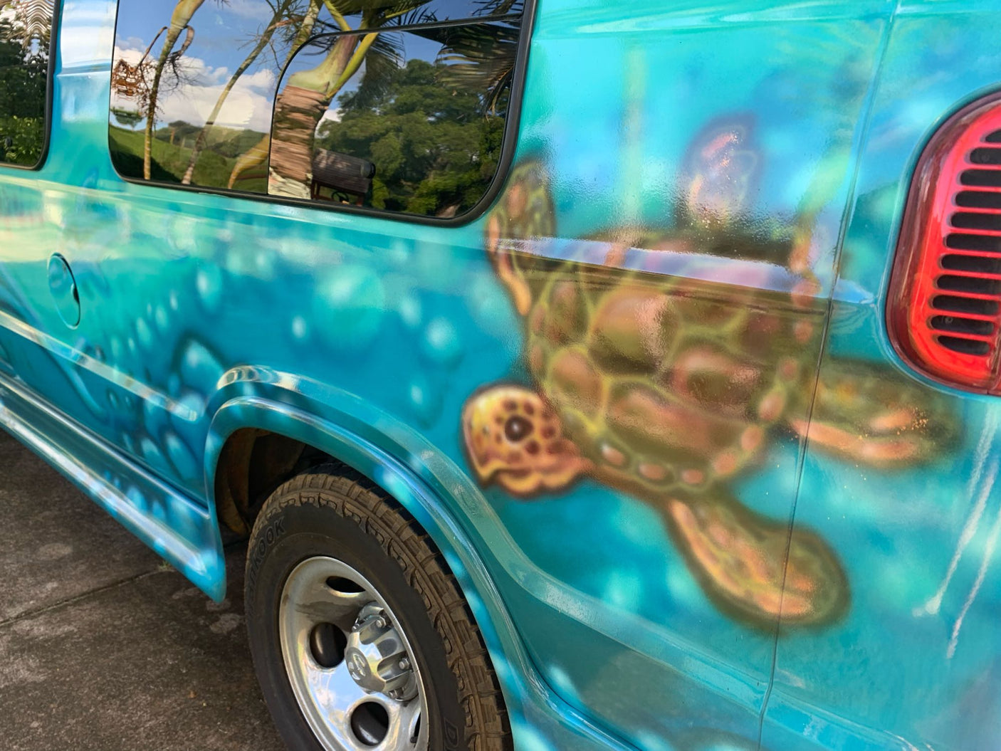 Unique turquoise RV rental features a vivid custom airbrush mural: a sea turtle in an ocean scene.