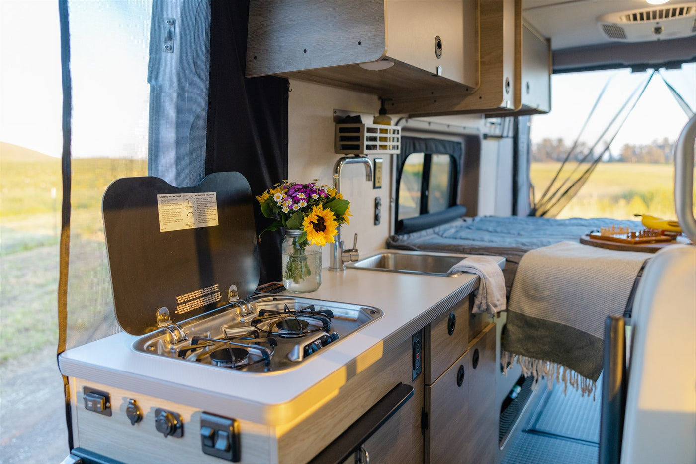  ready for adventure.|RV rental: Back doors open to a spacious campervan interior with bed & storage — photo 15