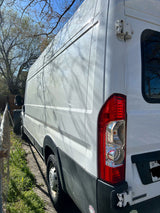 White RV rental van, parked outdoors with tree shadows on its side and rear.
