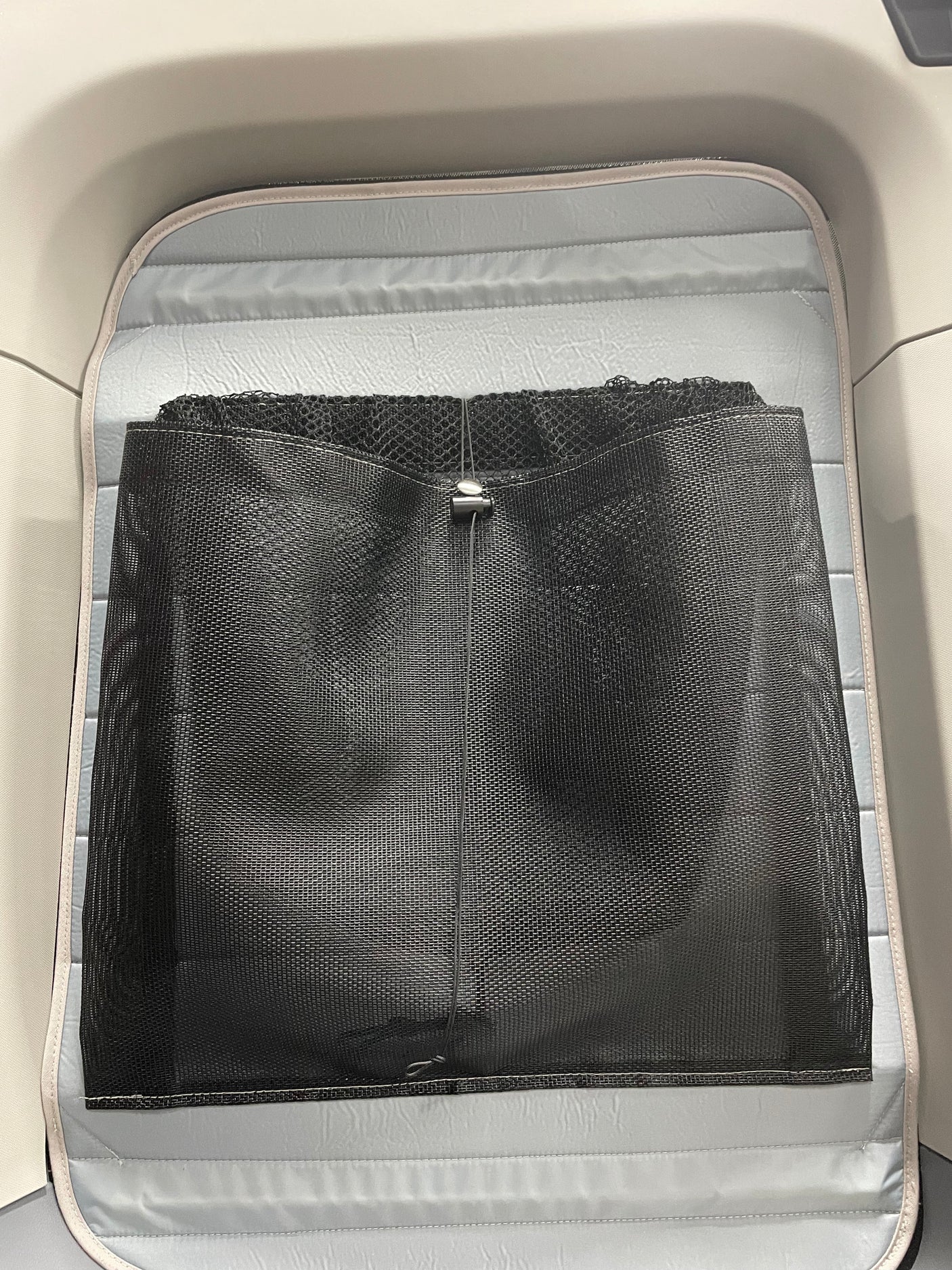 RV rental interior with a light gray padded base and a black mesh storage net for organization.