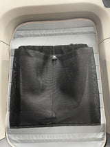 RV rental interior with a light gray padded base and a black mesh storage net for organization.