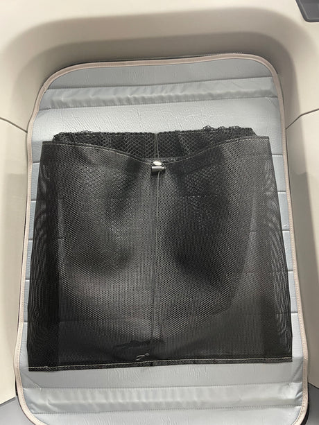 RV rental interior with a light gray padded base and a black mesh storage net for organization.