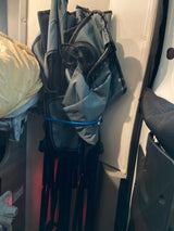Folded gray camping chair secured inside an RV rental, showcasing compact storage solutions for travel gear.