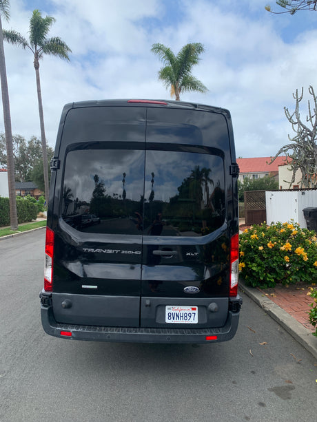 Rear view of a black Ford Transit 350HD XLT van, popular for rv rental conversions, parked on a California street.