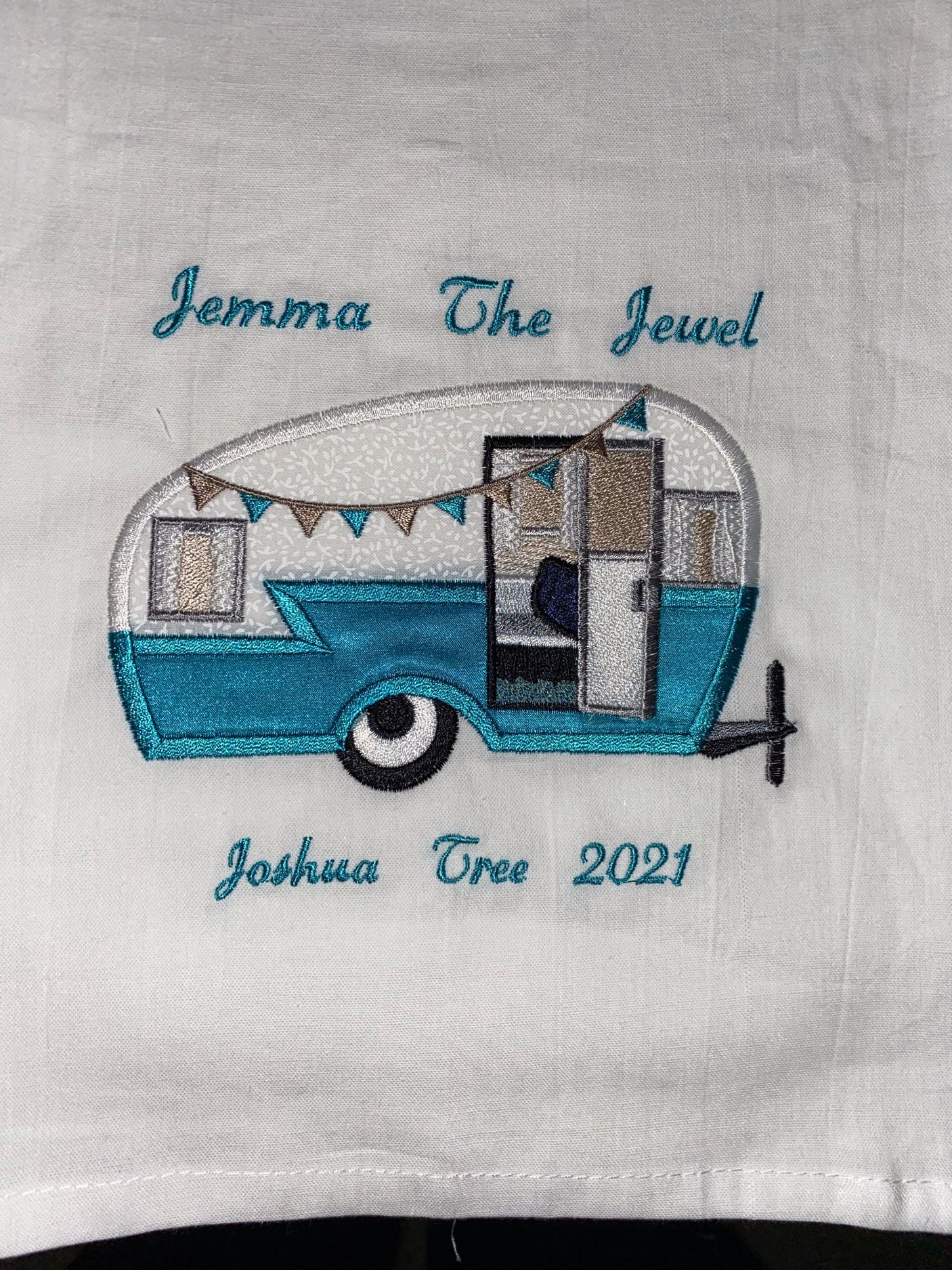 White fabric with embroidered vintage camper and "Jemma The Jewel," "Joshua Tree 2021" text. Great for RV rental memories.