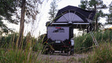 Overland camper trailer with rooftop tent deployed, perfect for an RV rental adventure into nature's off-grid beauty.