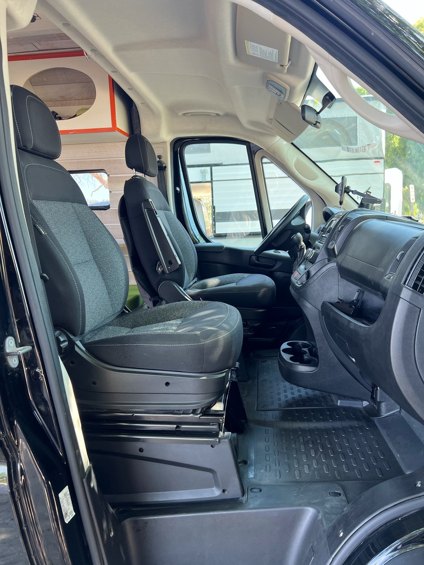  surrounded by lush green trees under a blue sky.|Black Ram ProMaster 2500 RV rental parked lakeside — photo 12