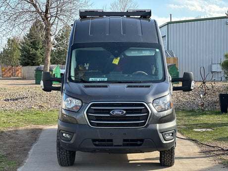 A dark grey Ford Transit rv rental van, equipped for travel, is seen head-on. This camper van is ready for adventure!