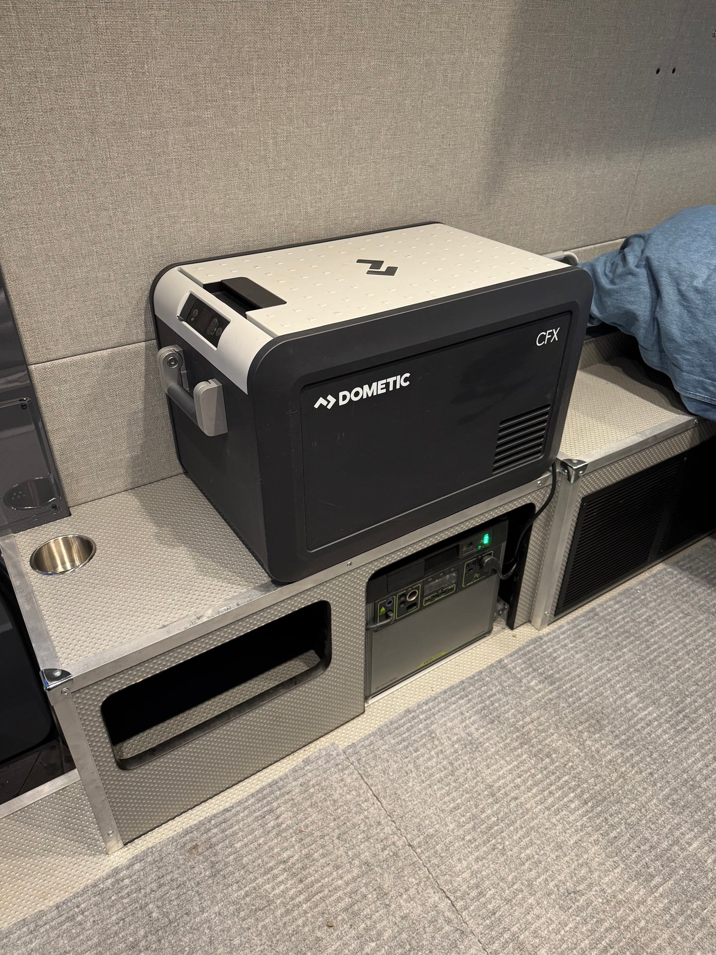 Inside an RV rental: Dometic CFX portable fridge sits on custom storage, powered by a Goal Zero Yeti station.