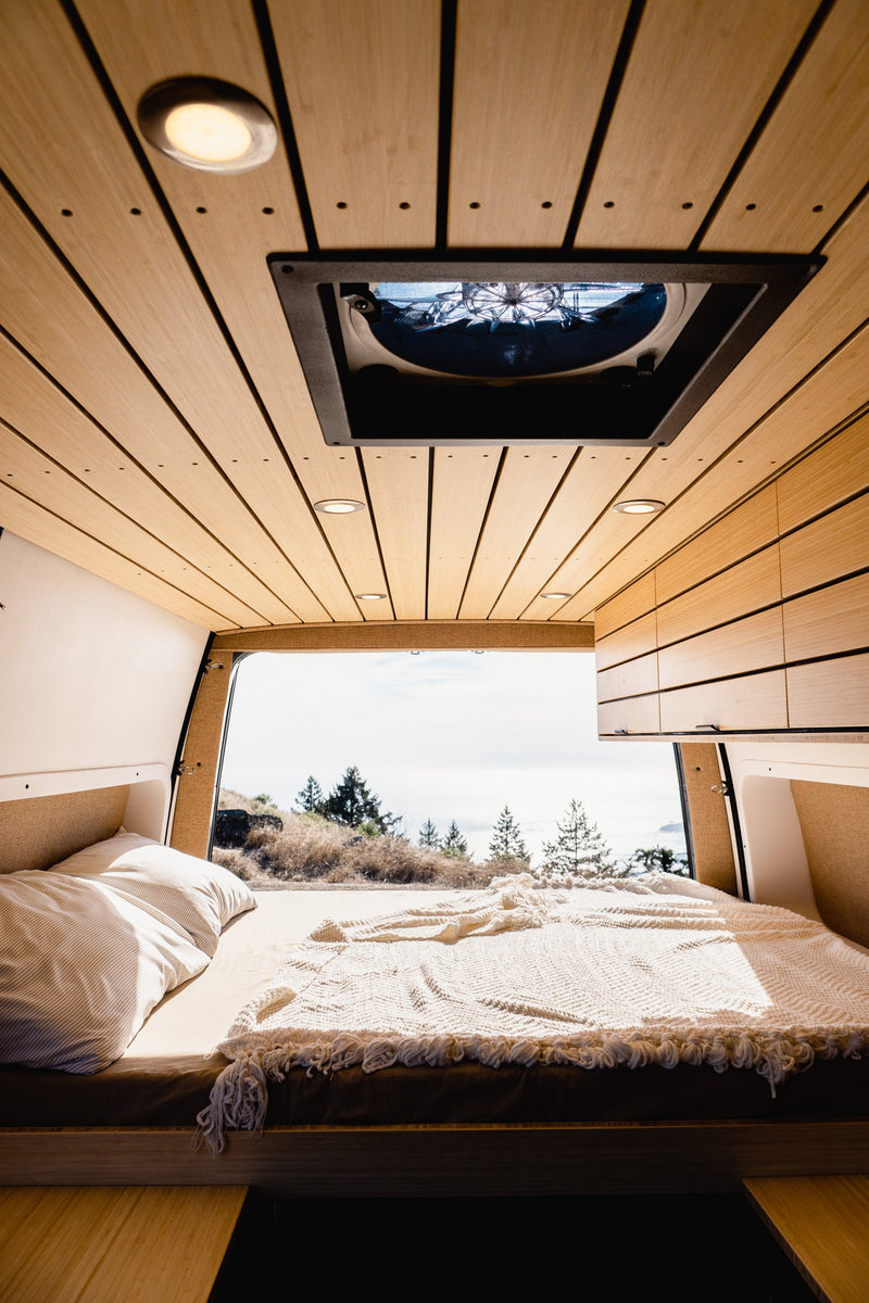  and a comfortable bed for your next van adventure.|Modern RV rental interior featuring a stylish wooden slatted ceiling — photo 6