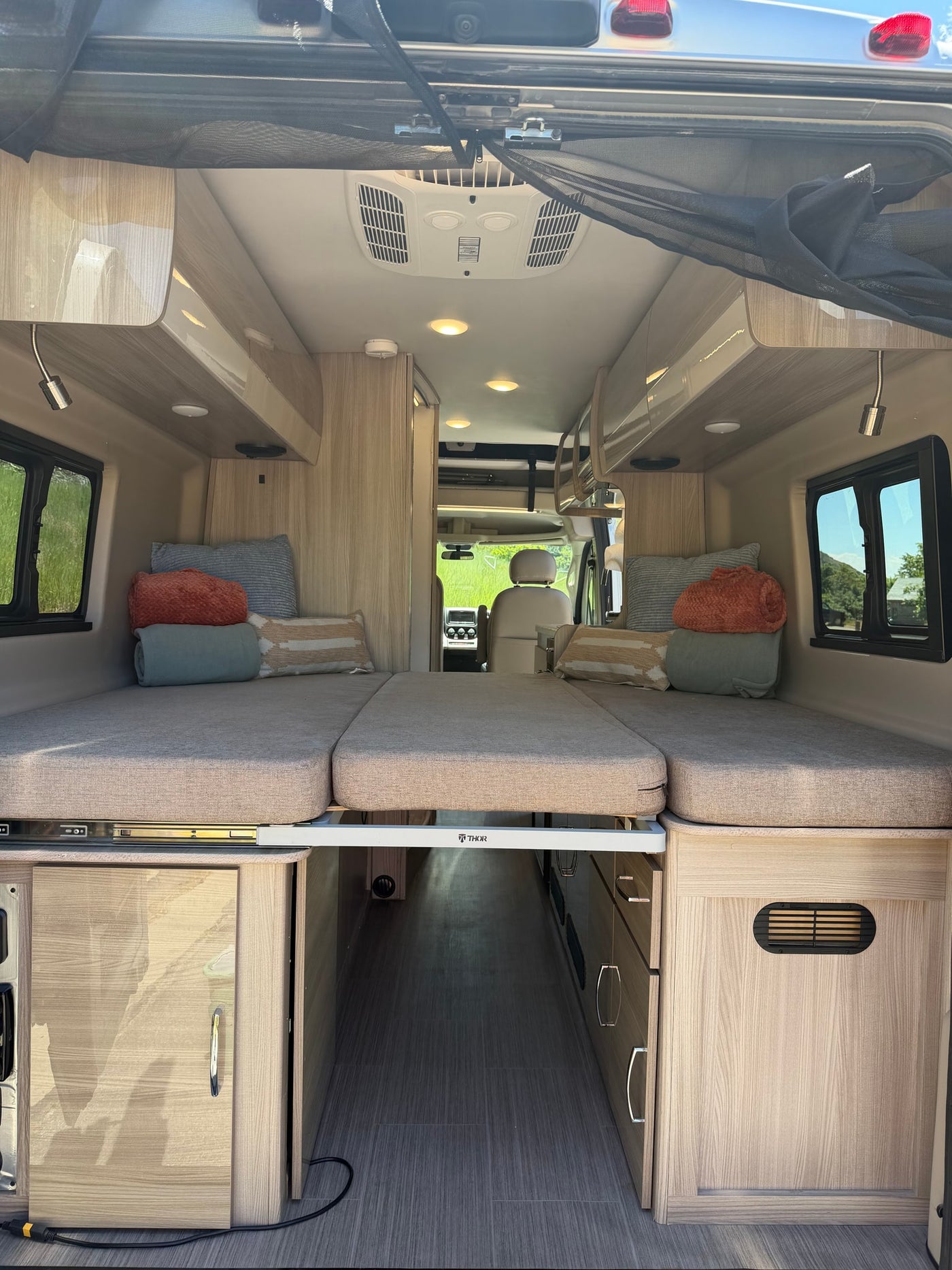 Inside this RV rental camper van: comfortable beds, ample storage, and a clear path to the driver's cabin for your road trip. — photo 13
