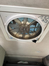 Overhead MaxxAir ceiling fan (dusty) with airflow & rain sensor controls in an RV rental for ventilation.