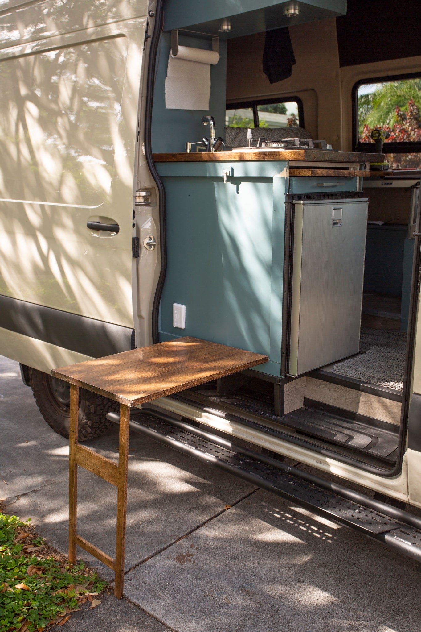 Step into this RV rental's clever interior: a mini kitchen with fridge & sink, plus an outdoor table for convenience. — photo 6