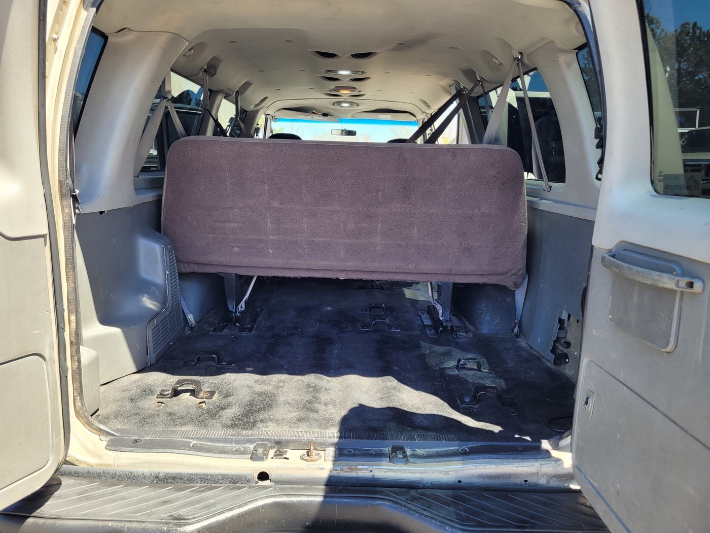 Rear interior of an RV rental van, showing the back bench seat and versatile floor for cargo/seating. — photo 7
