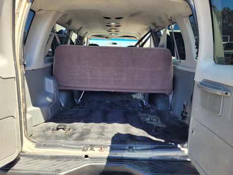 Rear interior of an RV rental van, showing the back bench seat and versatile floor for cargo/seating.