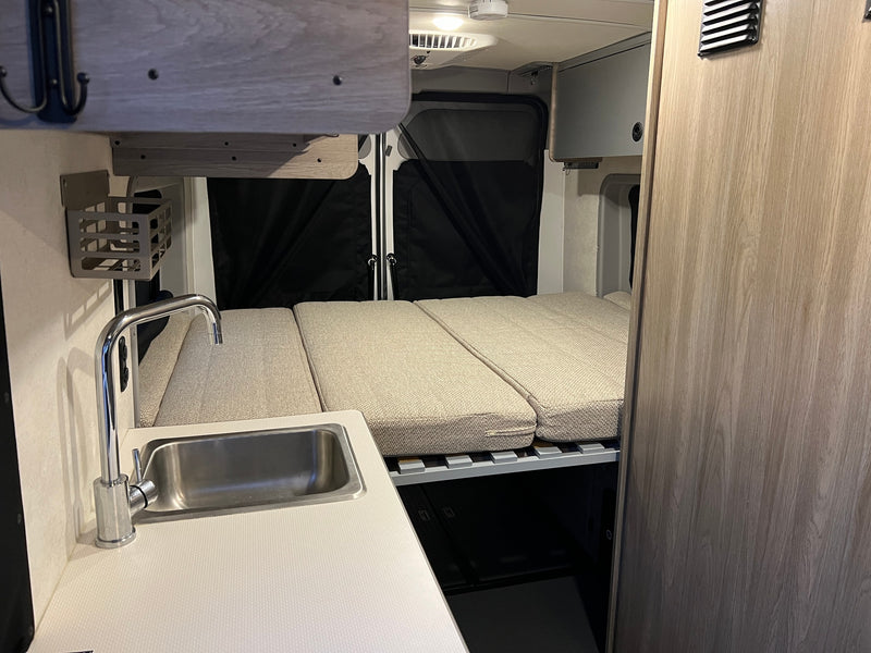 Cozy RV rental interior with kitchenette, bed, and storage. Perfect for adventures. — photo 8