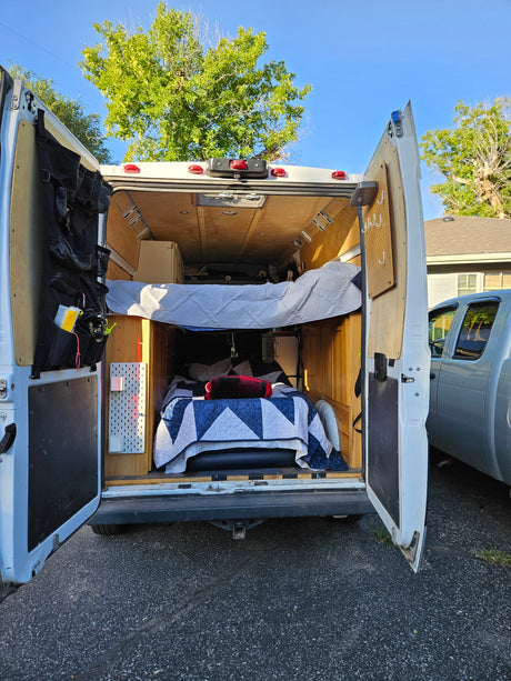 Explore this camper van conversion, ideal for an RV rental. Features a cozy interior with beds and smart storage solutions.