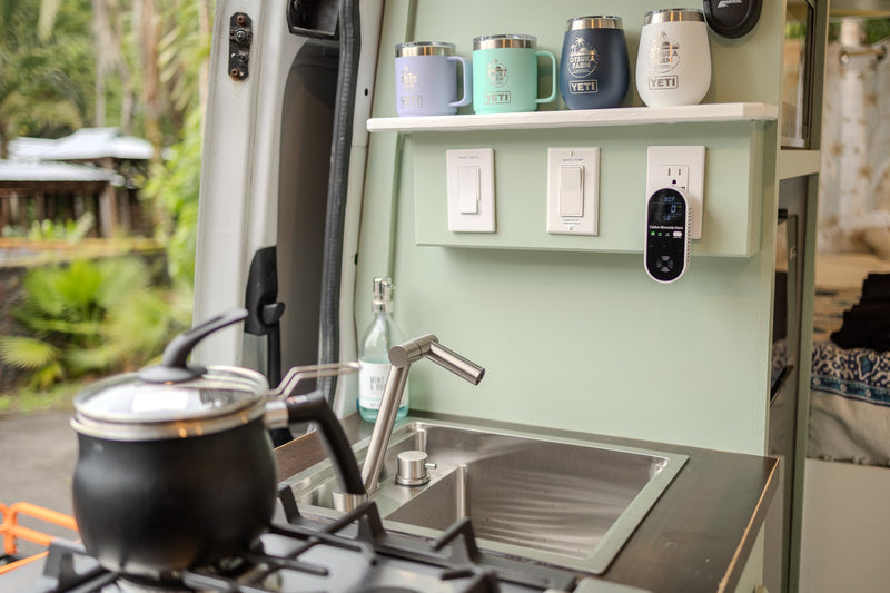 RV rental kitchen: cozy interior with sink, stove, custom mugs, & CO alarm for safety. Perfect for your adventure. — photo 9