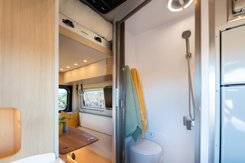  and scenic desert views.|Modern rv rental interior featuring a bright dining area with white benches — photo 10