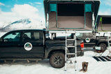 Discover snowy Alaska mountains! Black pickup truck with roof-top tent. A practical RV rental for your next outdoor adventure.