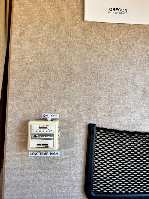 RV rental control unit on a textured wall: ON/OFF switch, thermostat with LOW TEMP HIGH settings, and an 'Oregon' sign.
