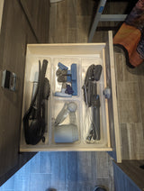 RV rental kitchen drawer neatly organizes cooking utensils, measuring cups, and bag clips for compact living.