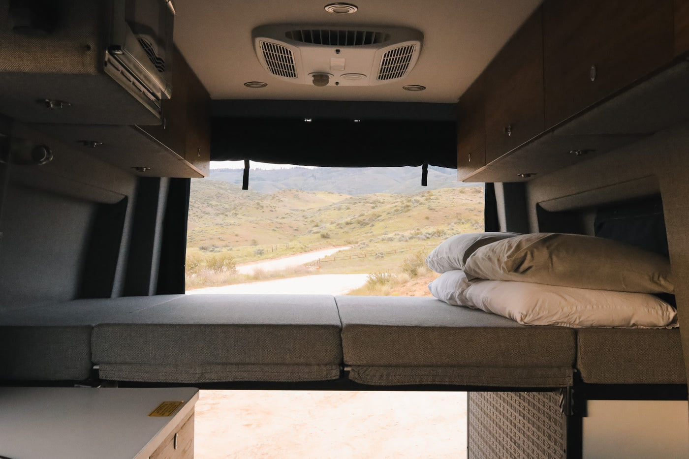  and integrated controls for travel.|RV rental interior: convertible black leather seating with seatbelts — photo 6