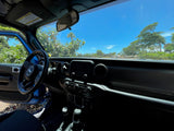 View from a blue Jeep's interior: dashboard, steering wheel, and sunny tropical scene outside. Your adventure beyond a typical rv rental.